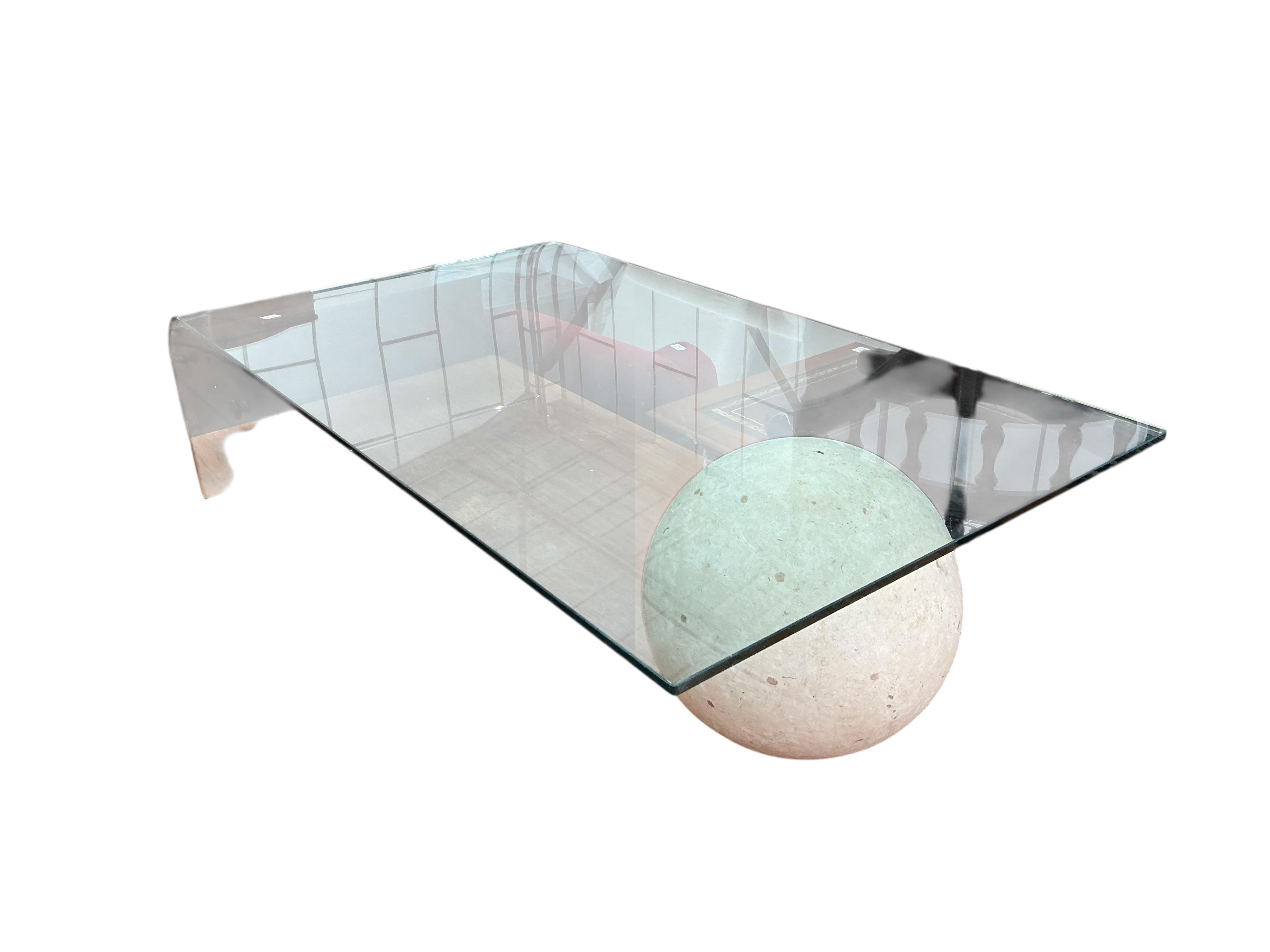 A Contemporary glass top coffee table with faux marble sphere support